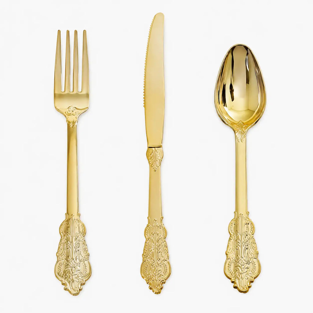 Gold vintage-style fork, knife, and spoon set with ornate handles on white background