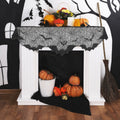 Black spider web mantel scarf with bat details displayed on a Halloween fireplace setup