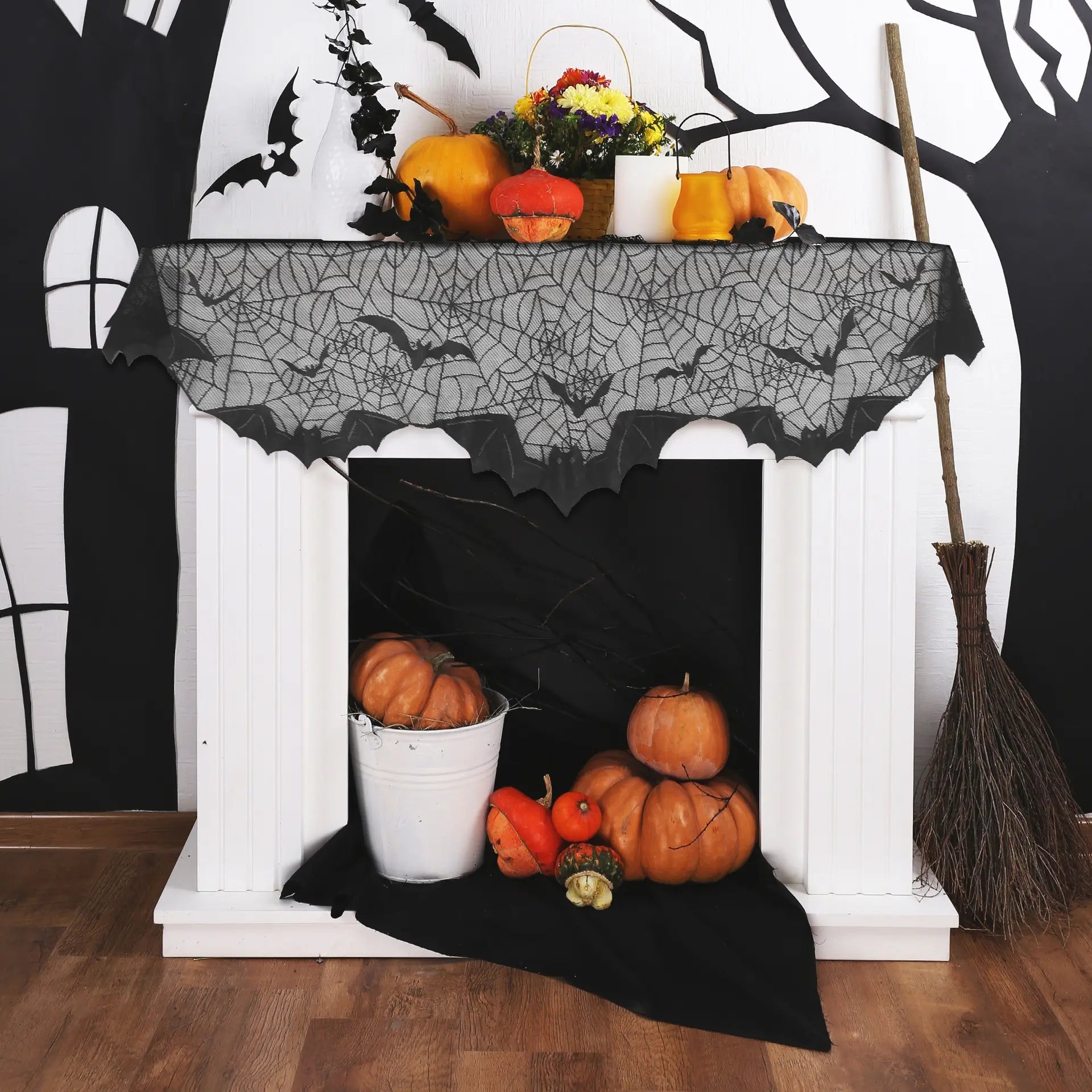 Black spider web mantel scarf with bat details displayed on a Halloween fireplace setup